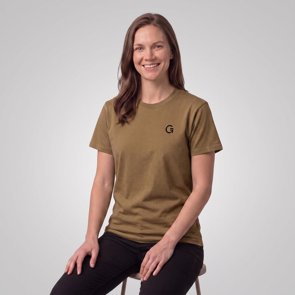 A woman modelling an army colour t-shirt with a black embroidered ‘Clobber & Gear’ logo on the left chest, paired against a light grey studio background.