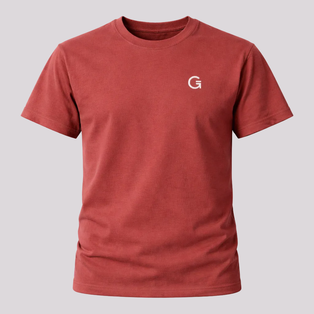 A berry red crewneck short-sleeve t-shirt with a white embroidered ”Clobber & Gear” logo on the left chest, displayed against a plain light grey background.