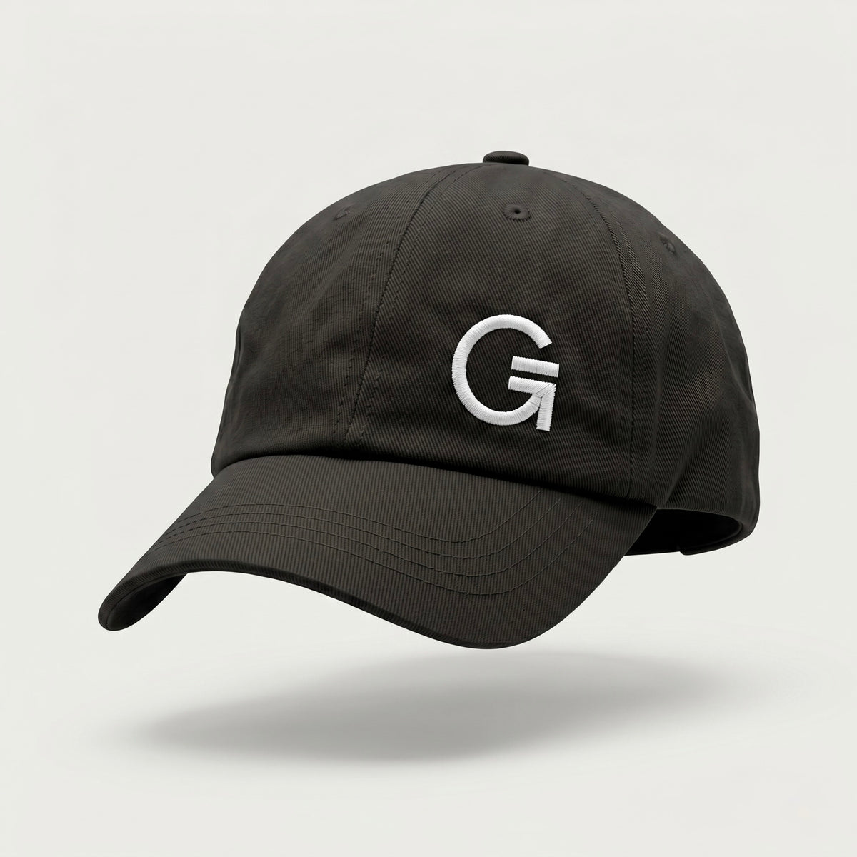 Front-three-quarter view of a black dad cap featuring a white embroidered "Clobber & Gear" logo on the front left panel, set against a soft off-white background.