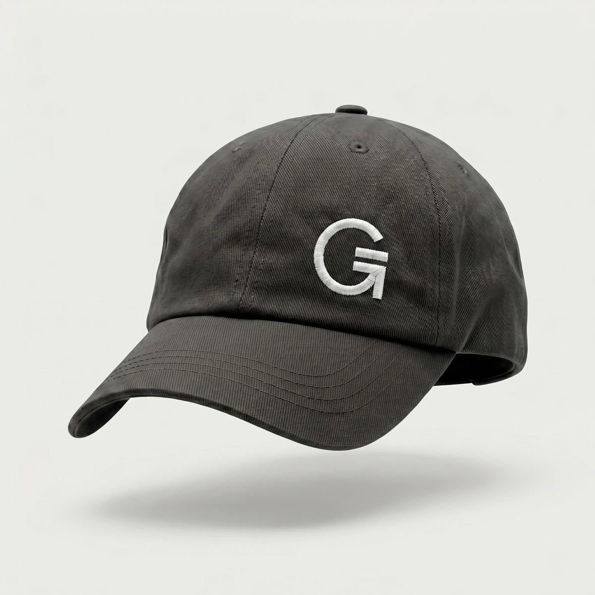 Front-three-quarter view of a mid-grey dad cap featuring a white embroidered "Clobber & Gear" logo on the front left panel, set against a soft off-white background.