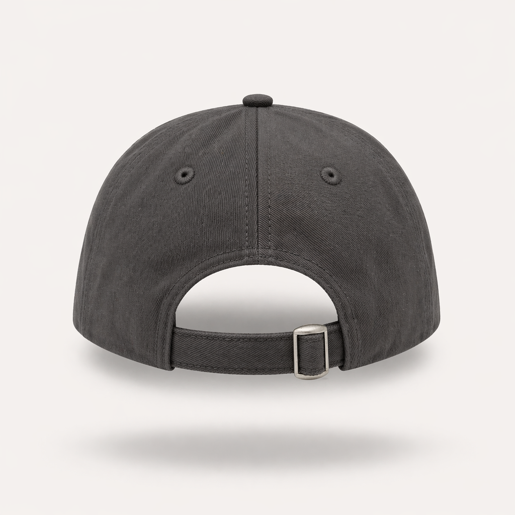 Rear view of a mid-grey dad cap featuring an adjustable fabric strap with a silver metal tri-glide buckle, embroidered eyelets, and stitched paneling set against a plain light background.